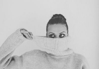 Close-up of woman wearing eyeglasses against white background