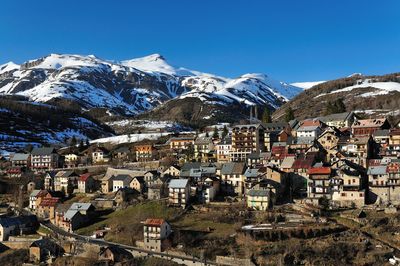 Aerial view of townscape by mountain against clear sky