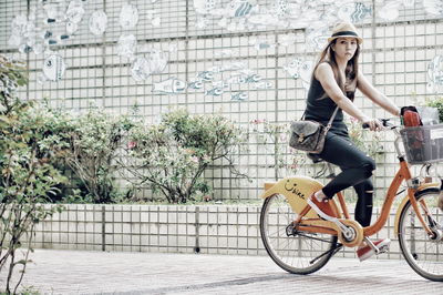 Full length of woman with bicycle in city