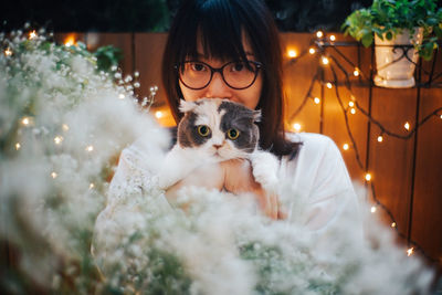 Portrait of woman with cat at home