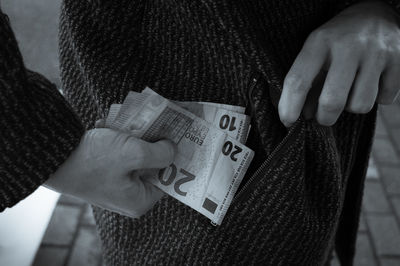 Midsection of woman holding paper currency