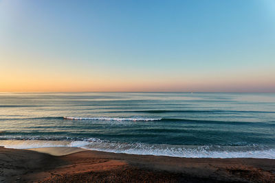 Scenic view of sea against clear sky during sunset