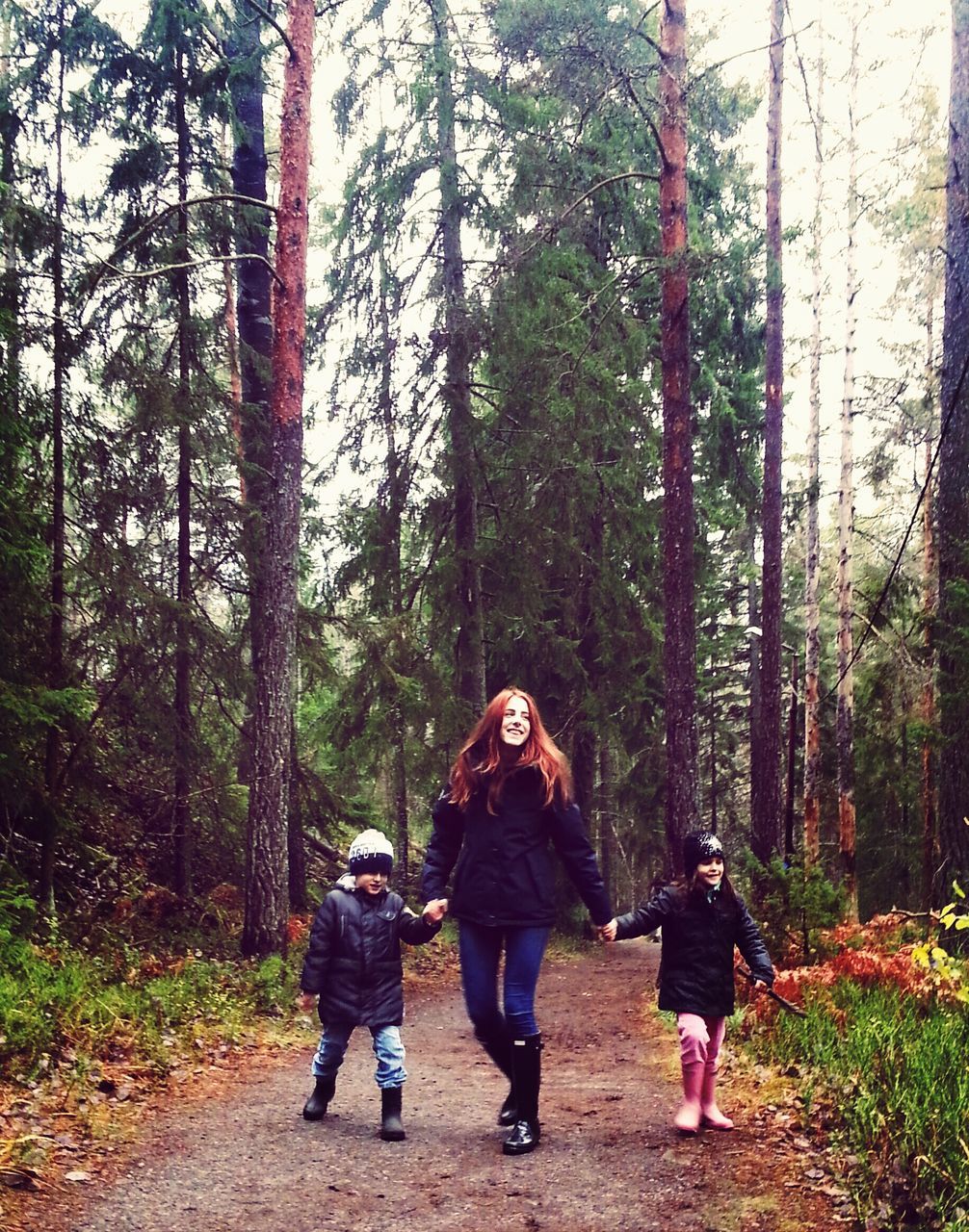 YOUNG WOMAN STANDING IN FOREST