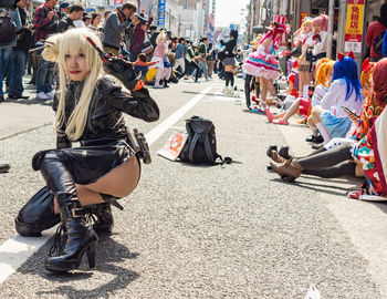 People sitting on road in city