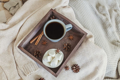 High angle view of coffee cup on bed