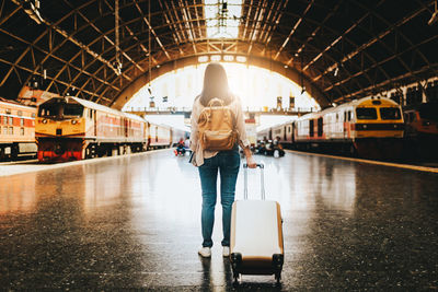 Rear view of woman walking on railroad station