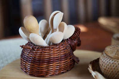 Close-up of wooden spoons in basket on table