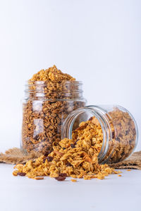 Close-up of bread in jar against white background