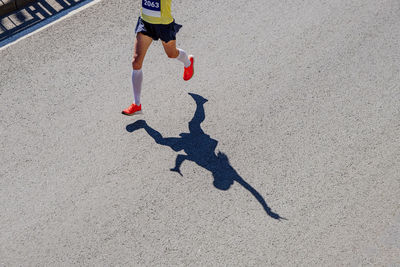 Low section of woman walking on road