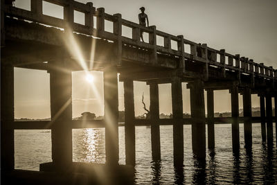 Bridge over river against sky during sunset