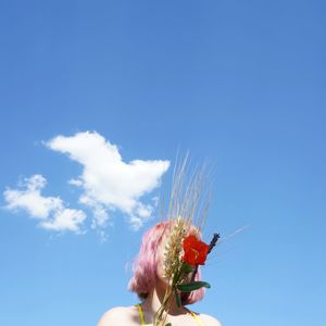 Low angle view of person hand against blue sky