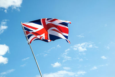 Low angle view of flag against blue sky