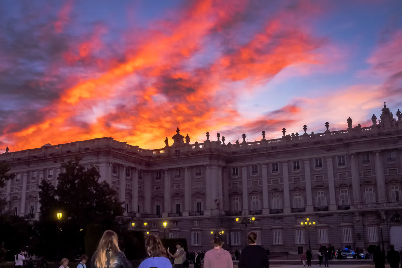 architecture, building exterior, built structure, evening, city, group of people, travel destinations, sky, nature, crowd, night, large group of people, cloud, illuminated, travel, tourism, dusk, sunset, outdoors, cityscape, city life, history