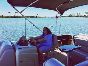 Mature woman driving boat on sea