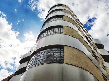 Low angle view of modern building against cloudy sky