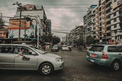 Cars on street against buildings in city