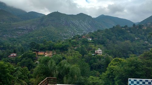 Scenic view of townscape and mountains against sky