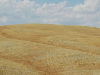 Scenic view of sand dunes against sky