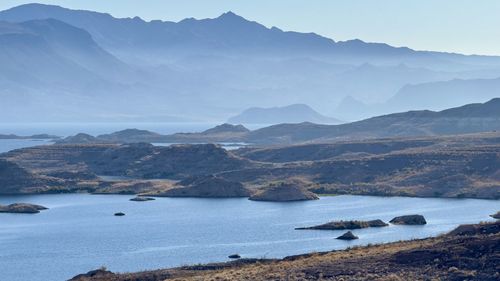 Scenic view of sea and mountains against sky