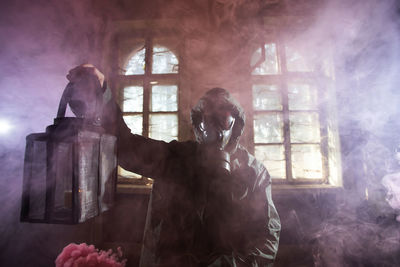 Man holding statue by window of building