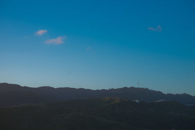 Scenic view of mountains against blue sky