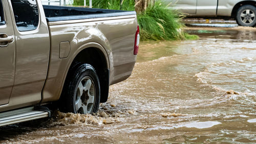 Pickup truck passing through flooded road. driving car on flooded road during flood.