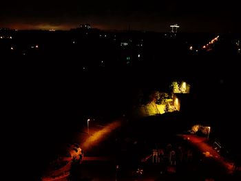 Illuminated city against sky at night