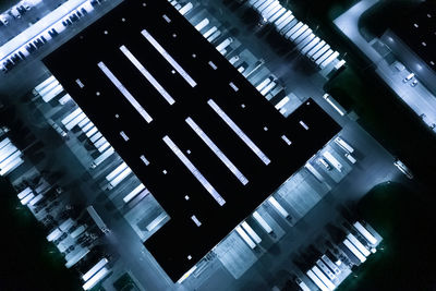 Aerial view of goods warehouse night. logistics center in industrial city zone trucks loading 