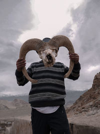 Rear view of man standing on land against sky