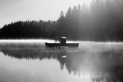 Built structure by lake against trees