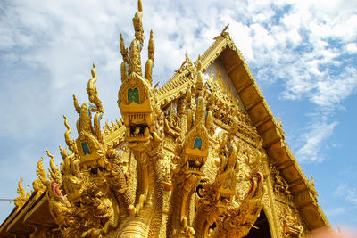 Low angle view of statue amidst buildings against sky