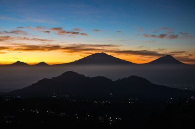 Scenic view of silhouette mountains against sky during sunset