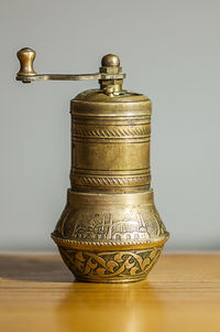 Close-up of old lamp on table against wall