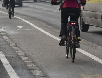 Rear view of man riding bicycle on road