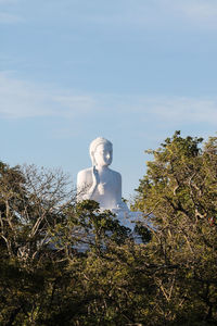 Statue against trees and sky