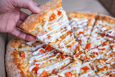 Cropped hand of person holding pizza