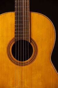 Close-up of guitar against black background