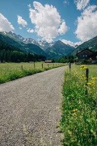 Road amidst field against sky