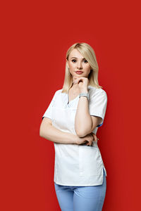 Portrait of a beautiful young woman against red background