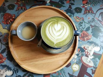 Top view leaf shaped on latte art coffee with art wall background