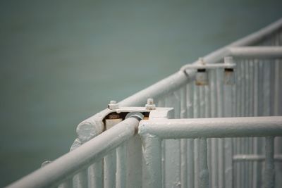 Close-up of metal railing against water