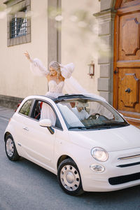 Couple embracing while standing in car