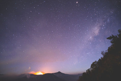 Low angle view of silhouette mountain against star field