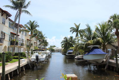 Boats in swimming pool by trees against sky