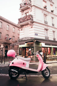 Motor scooter parked on street against buildings