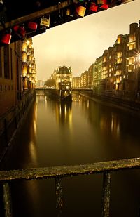 Bridge over river amidst buildings in city