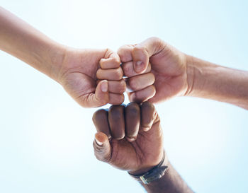 Cropped hand of person holding hands against white background