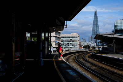 Railroad tracks amidst buildings in city against sky