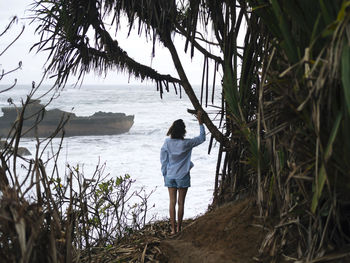 Young woman walking at ocean coastline