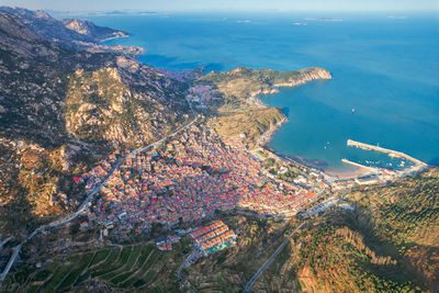 High angle view of townscape by sea against sky